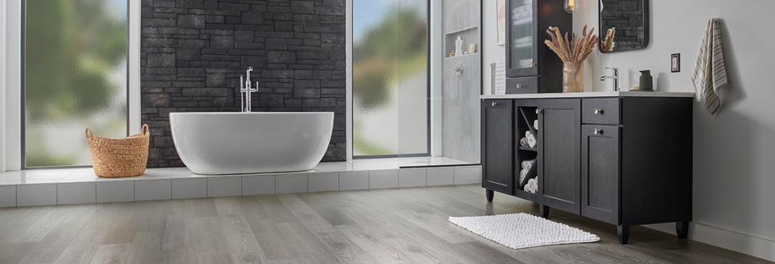 Mohawk luxury vinyl plank wood-look flooring in cool grey tones adds natural luxury to a large bathroom.